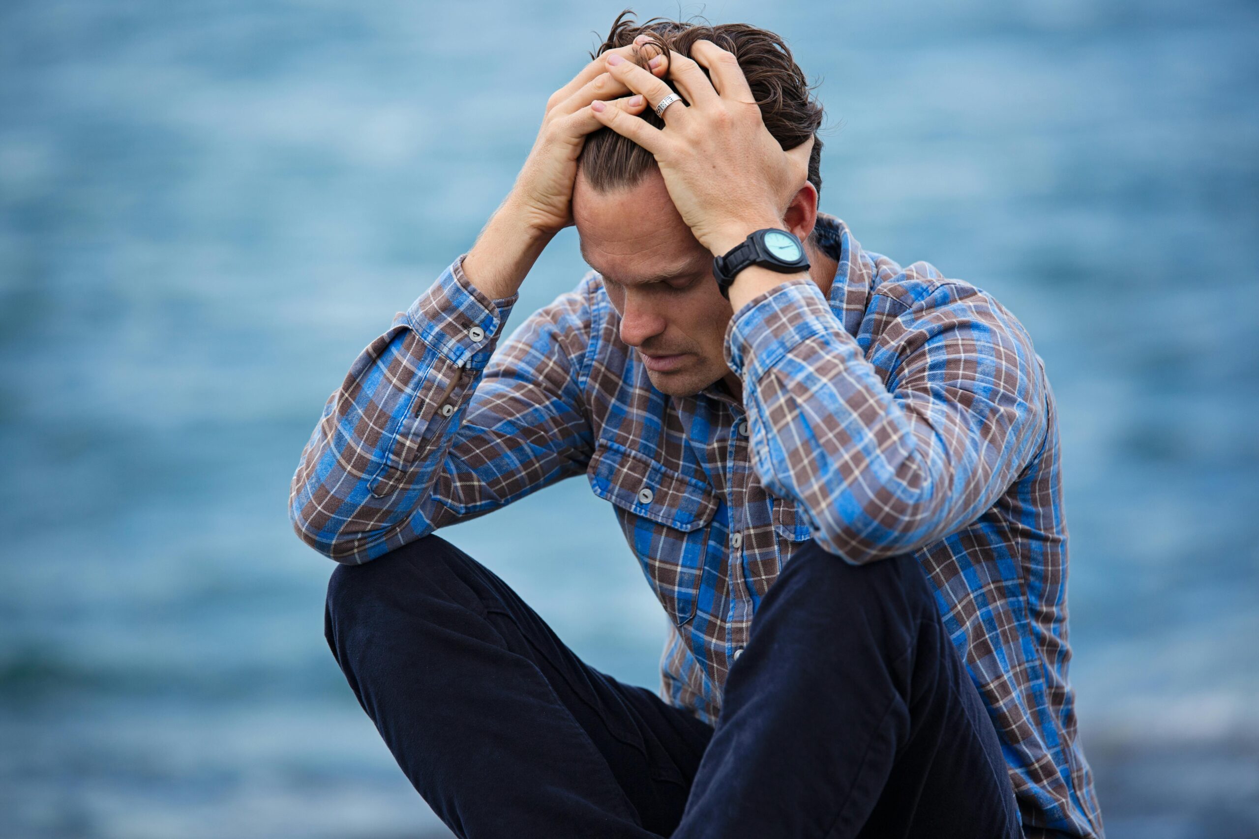 man with hands on head looking unhappy